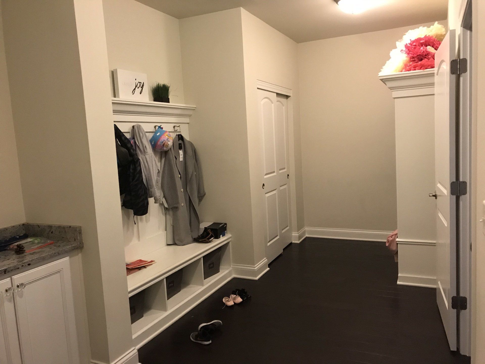 a hallway with a bench and a coat rack in a house .