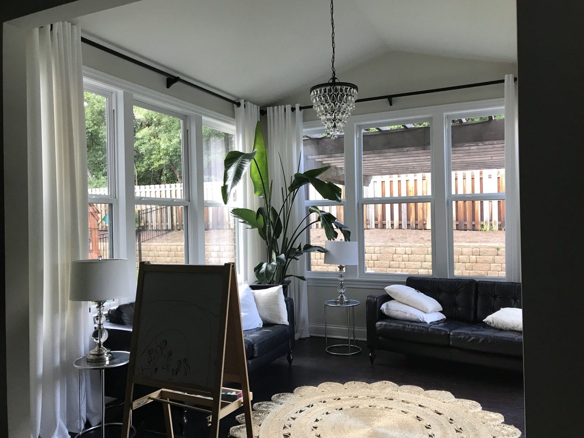 a living room with a black couch and a white rug