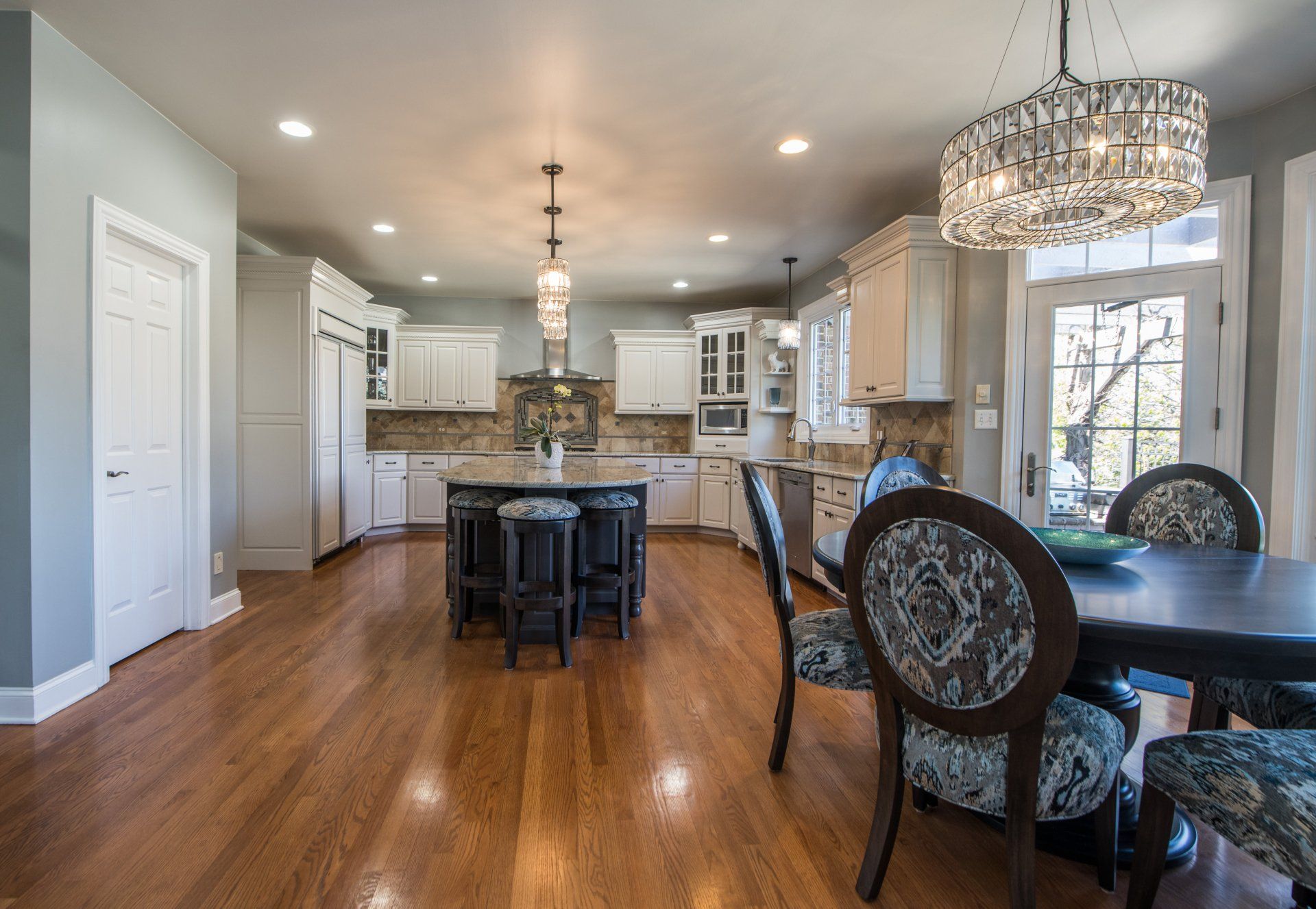 a kitchen and dining room in a house with hardwood floors and a table and chairs .