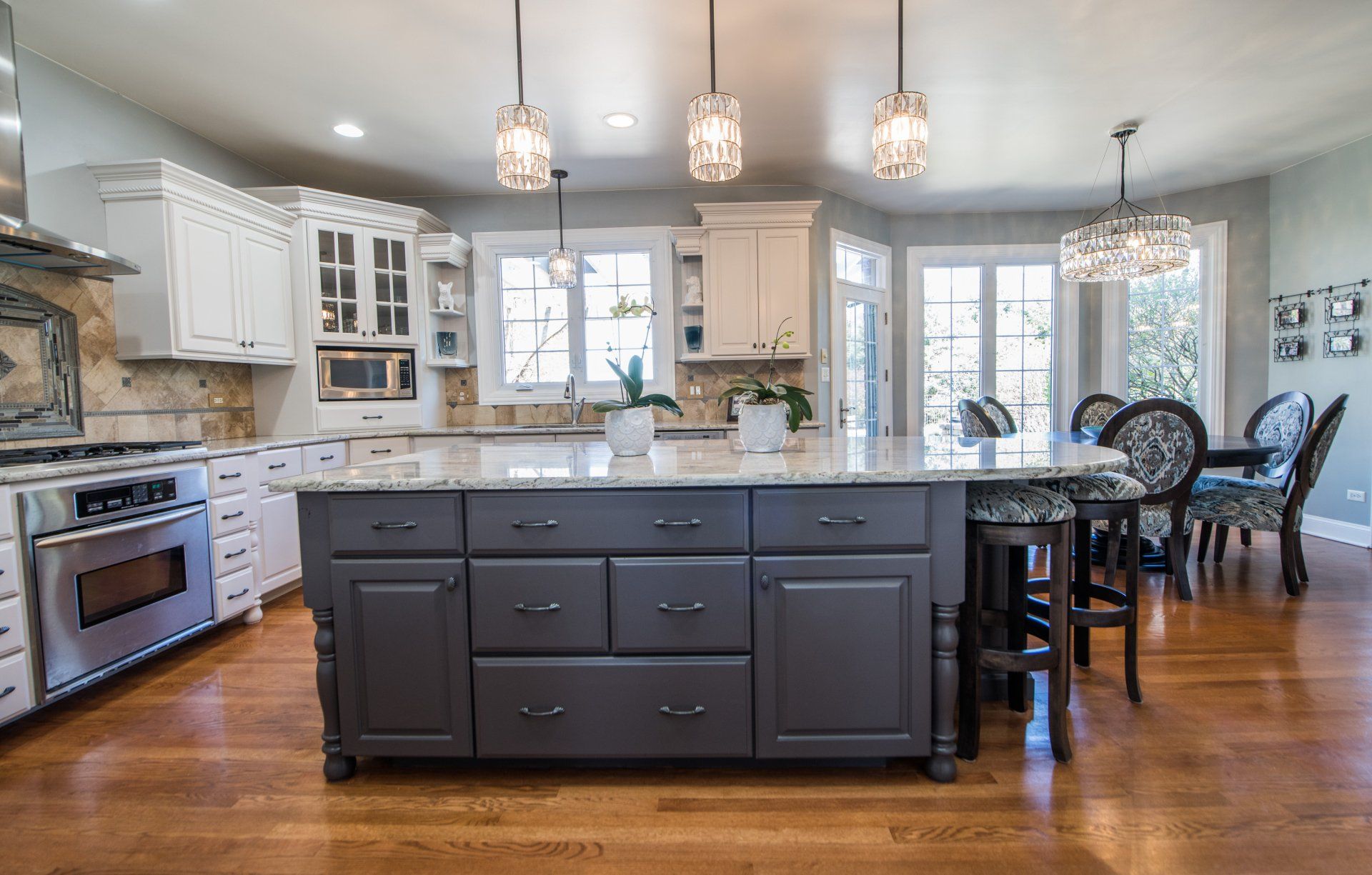 a kitchen with gray cabinets and a large island in the middle .