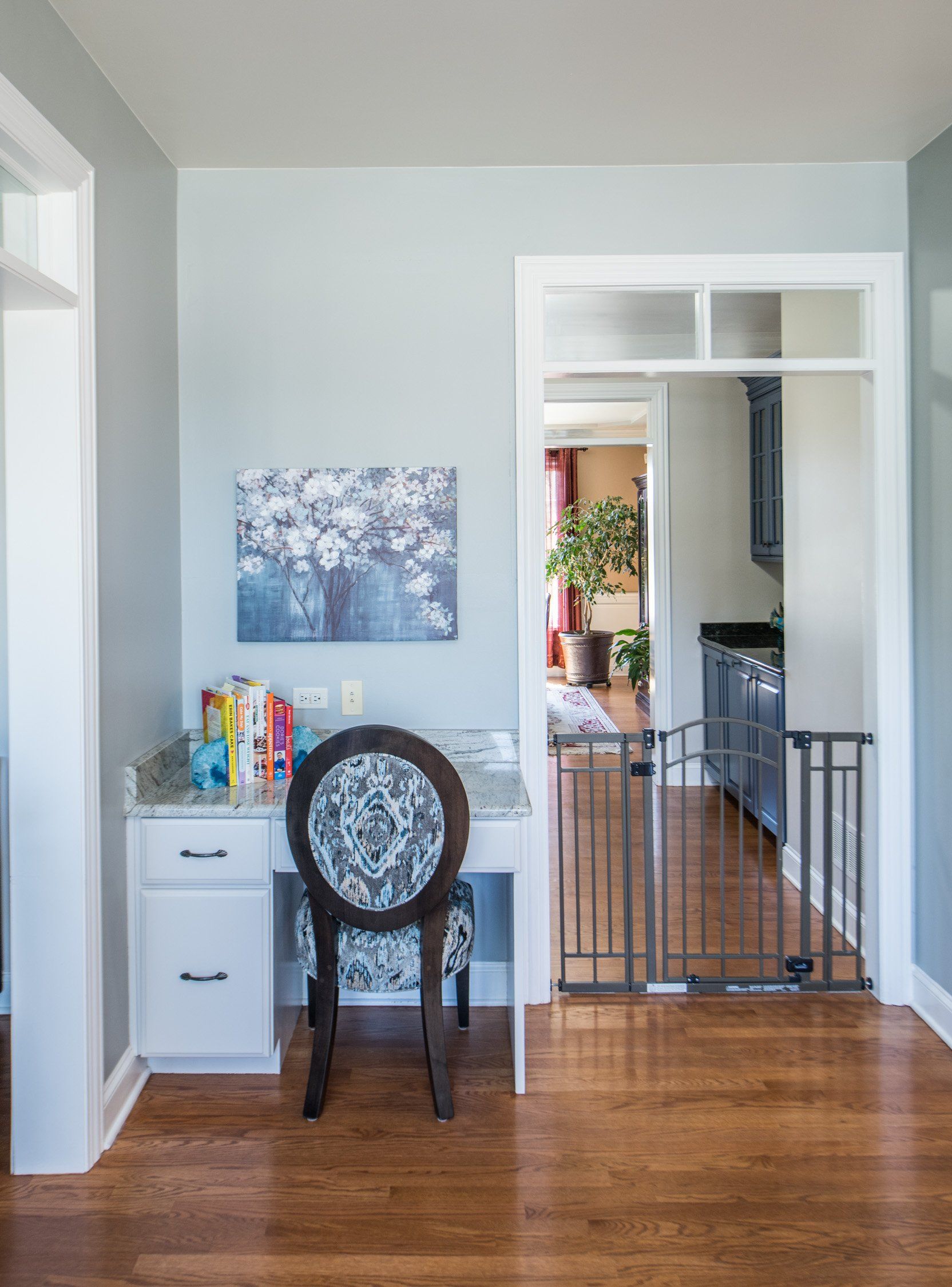 a room with a desk and chair and a painting on the wall .