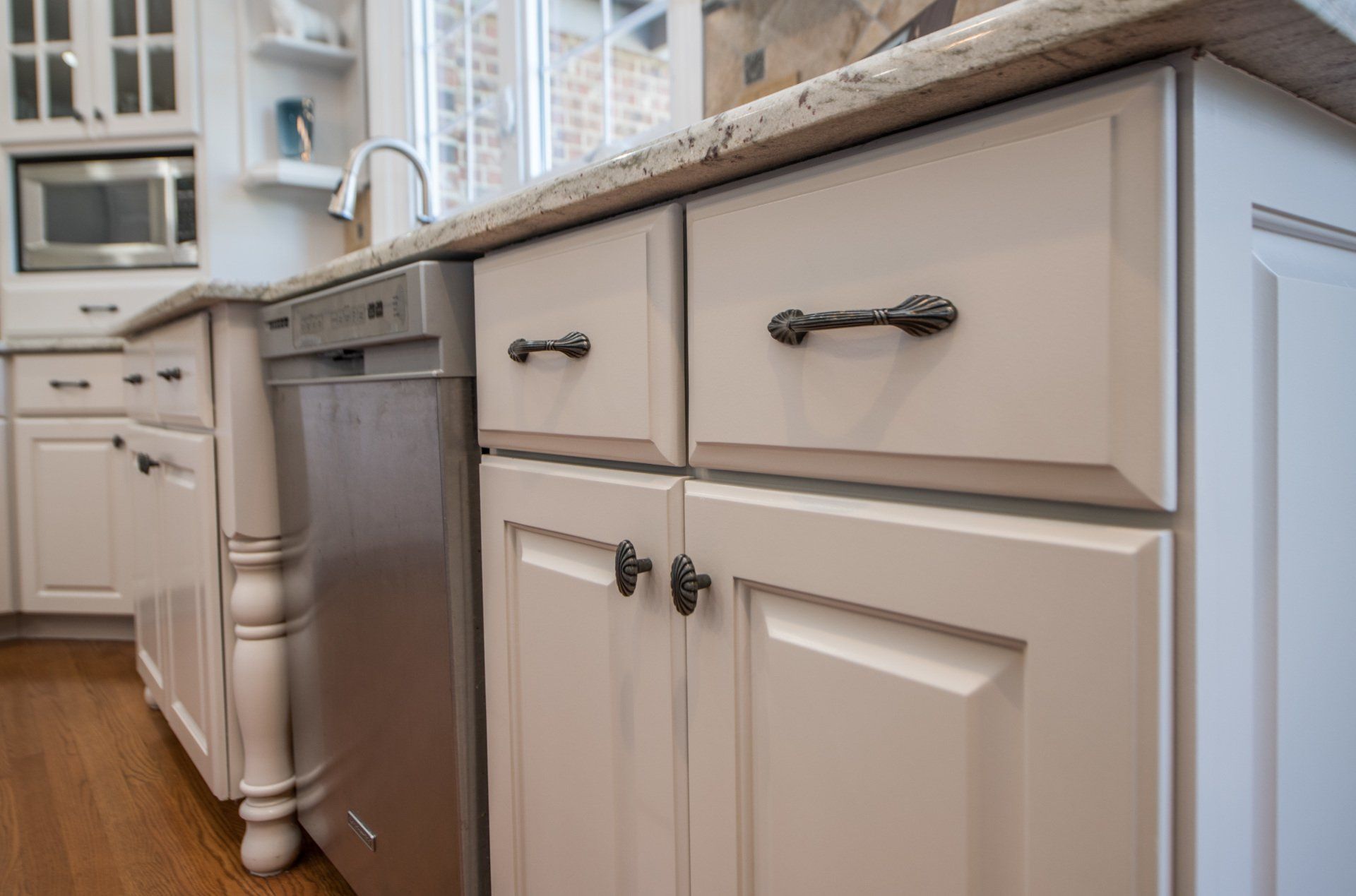 a kitchen with white cabinets and a stainless steel dishwasher .