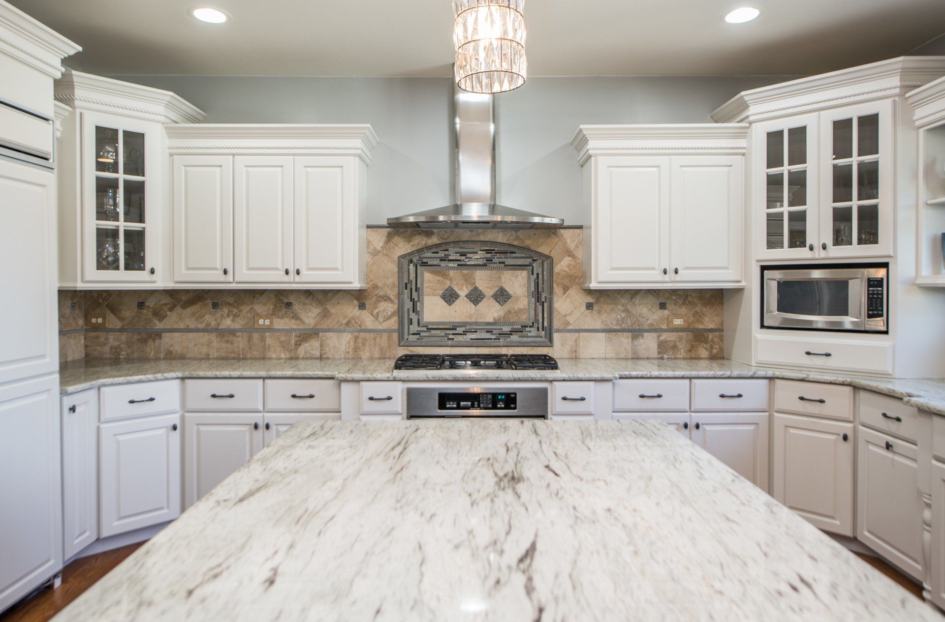 a kitchen with white cabinets and granite counter tops .