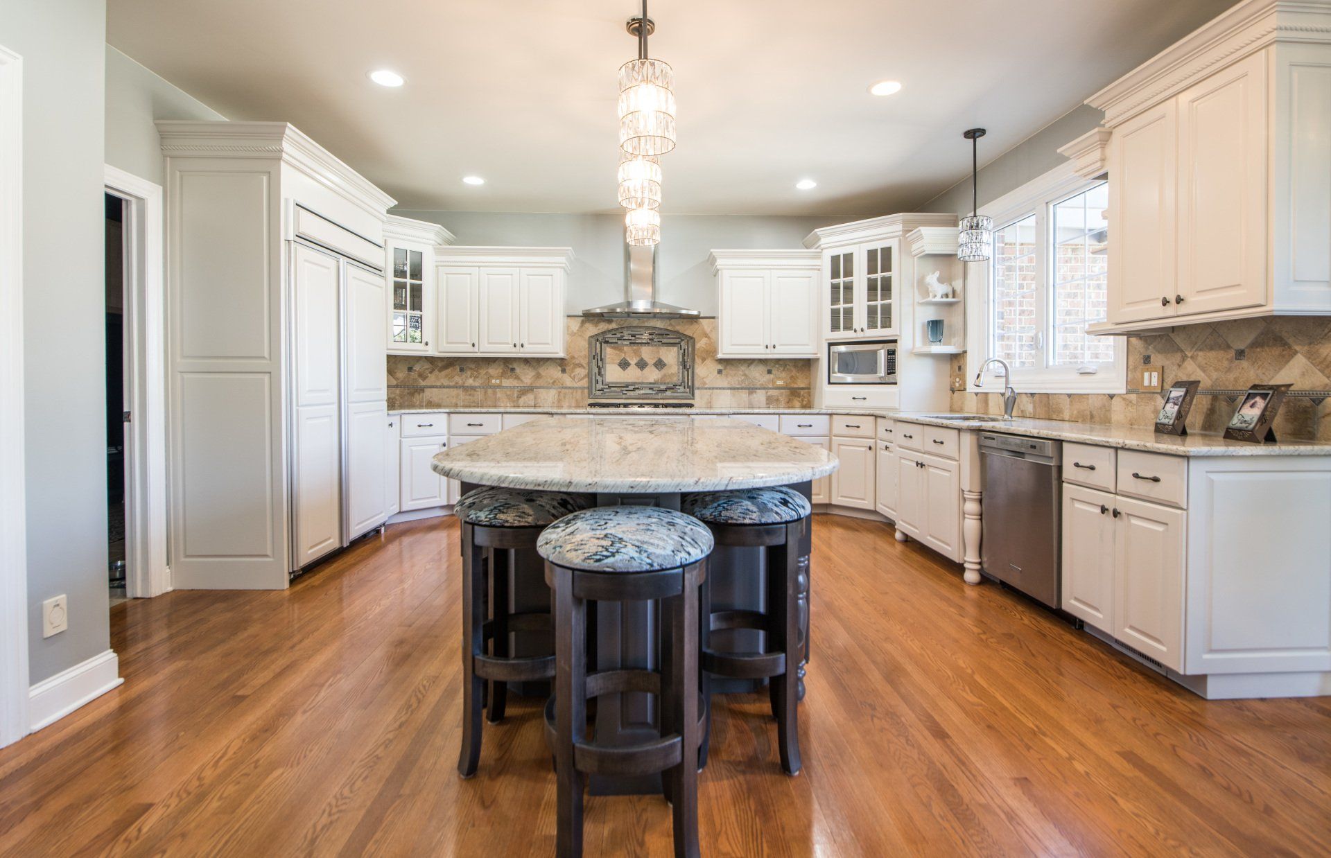 a large kitchen with a large island and stools .