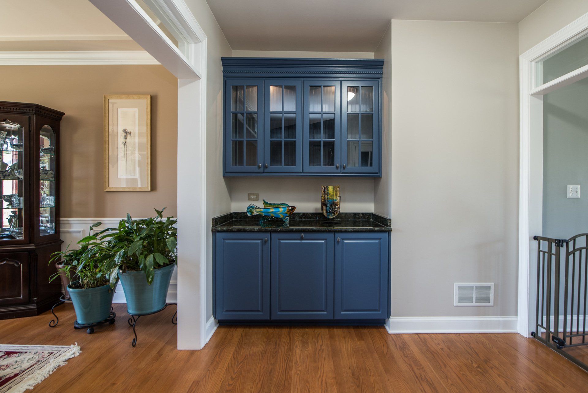 a living room with hardwood floors and blue cabinets .
