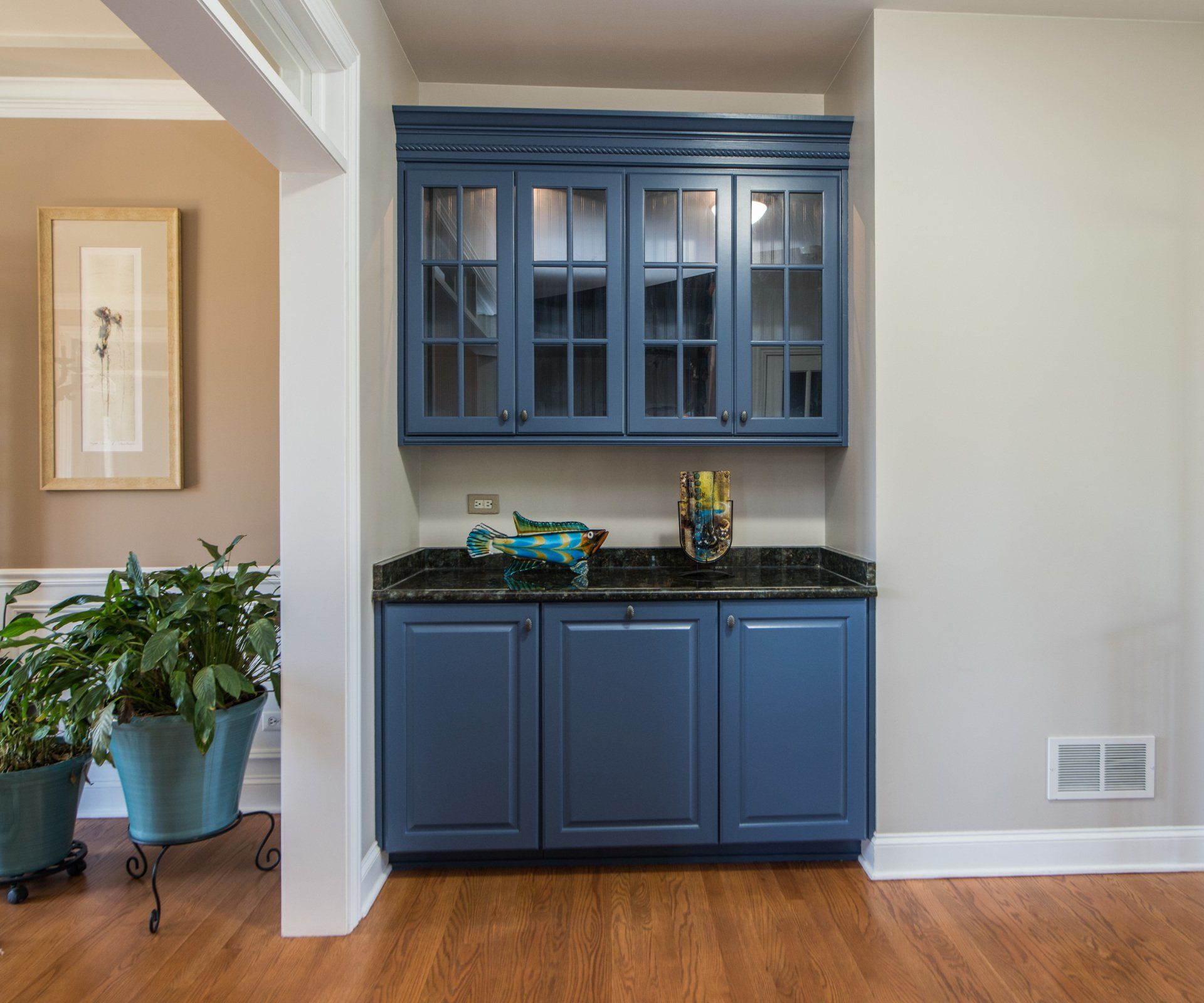 a kitchen with blue cabinets and a plant in a pot .