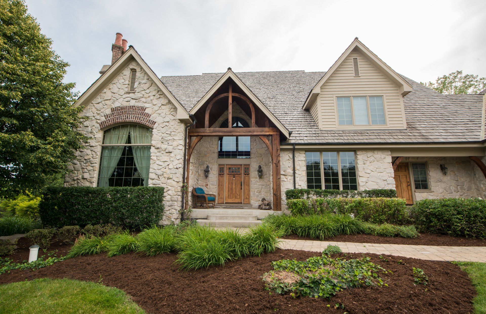 a large brick house with a wooden porch and a lot of windows