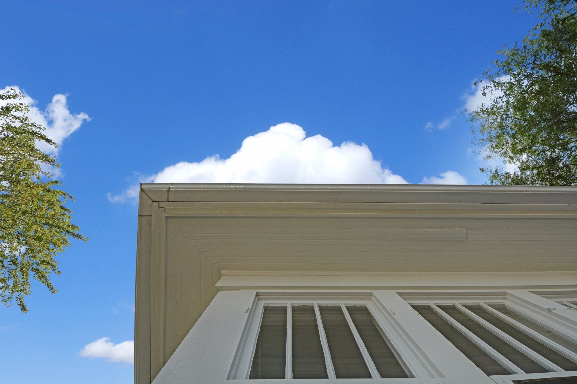 a house with a blue sky and white clouds behind it
