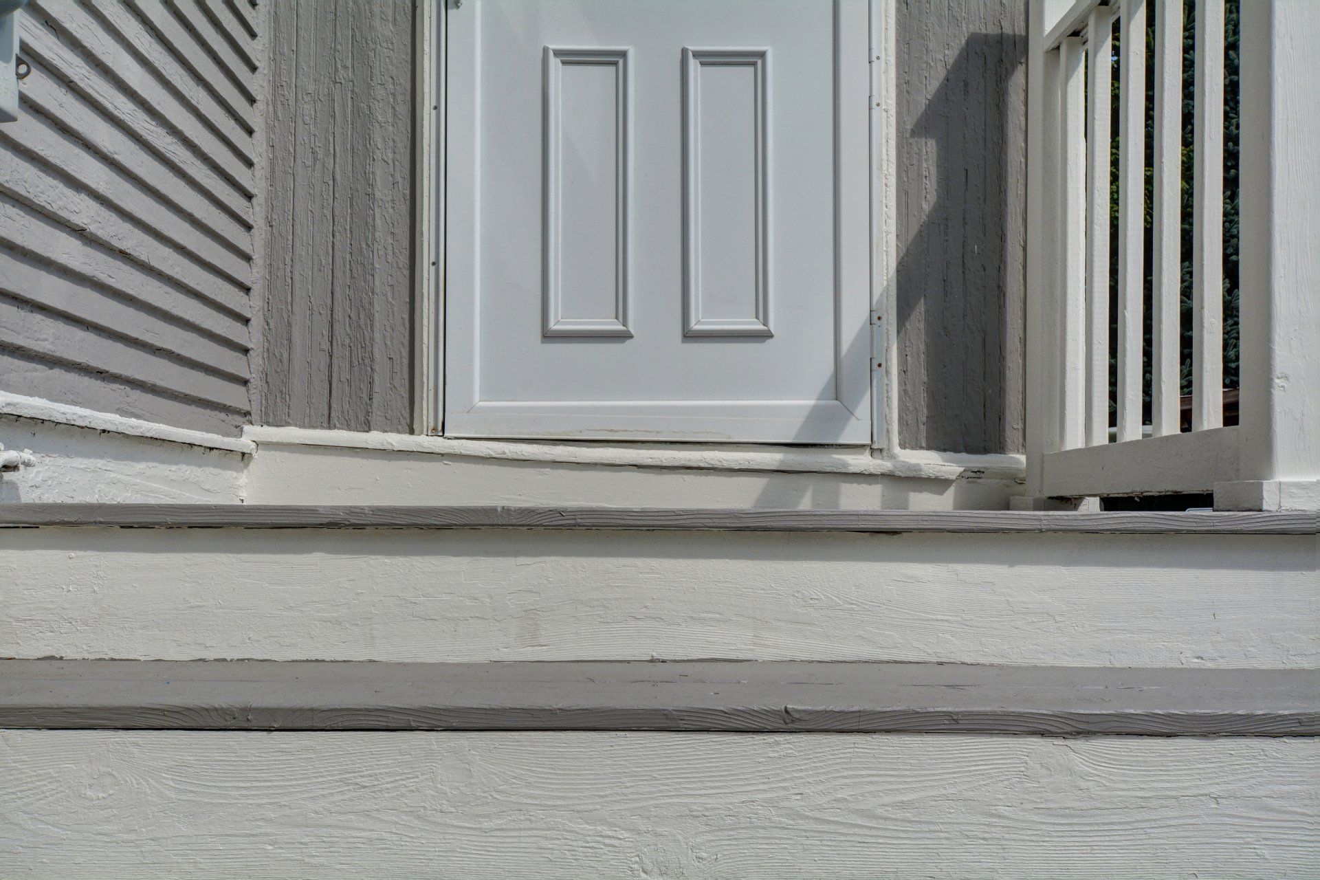 a white door is sitting on a porch next to a white railing .