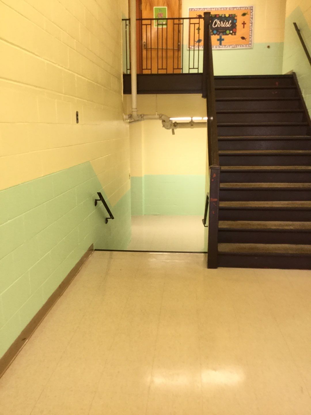 a hallway with stairs and a sign on the wall that says open