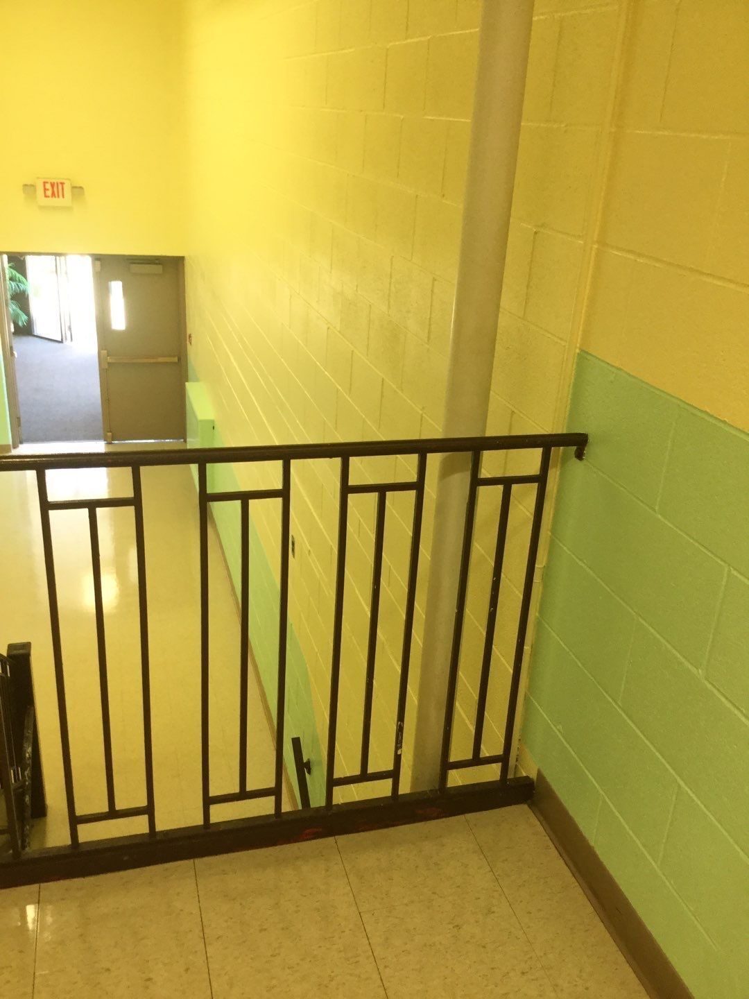 a staircase with a metal railing and a sign that says exit
