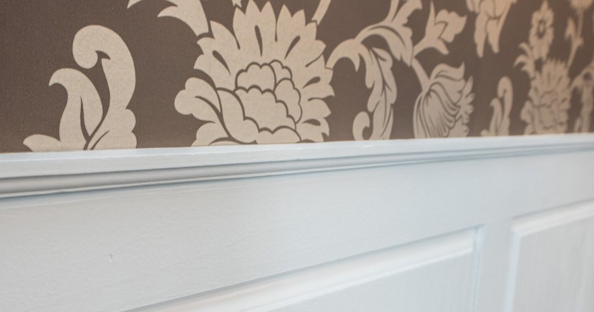 a close up of a wall with a floral wallpaper and a white trim .