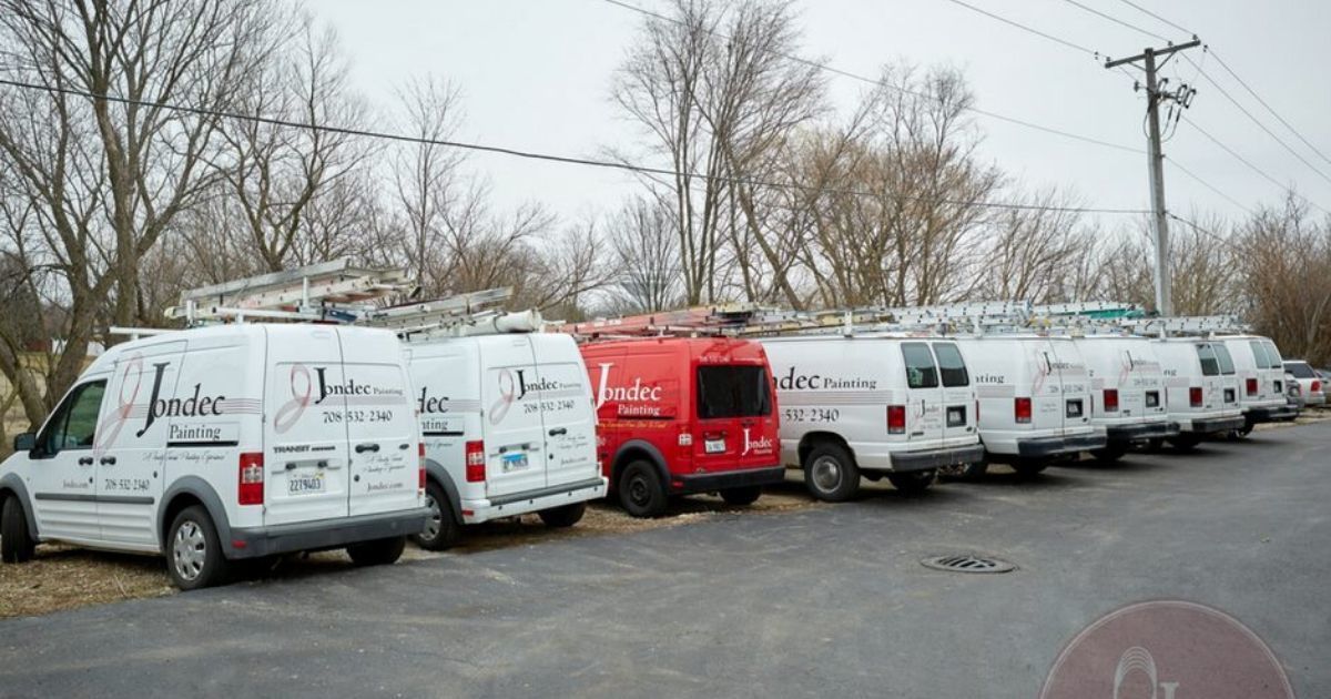 a row of vans are parked in a parking lot .