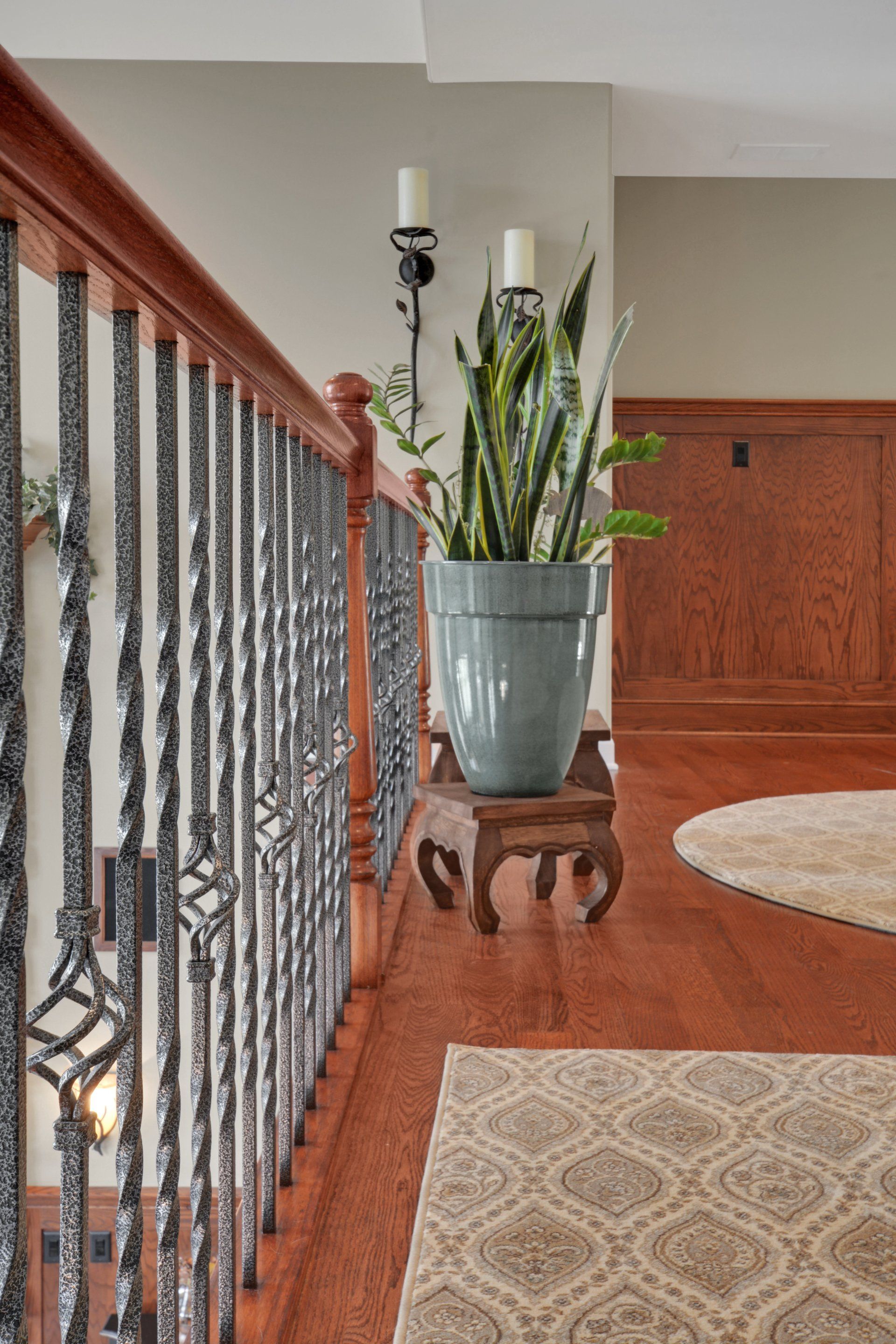 a potted plant is sitting on a wooden table next to a staircase .