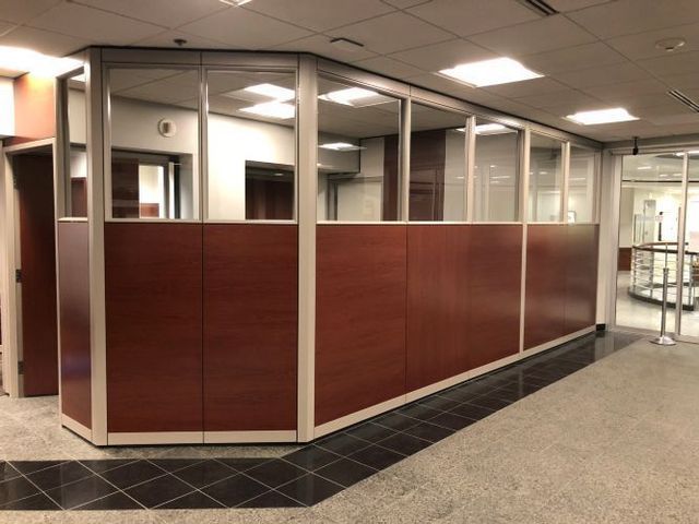A hallway with a wooden divider and a glass door