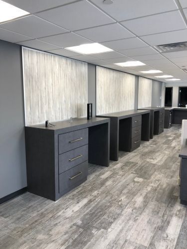 A row of desks and drawers in a room with a wooden floor.