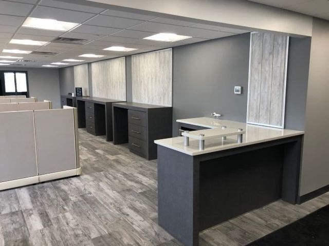 A large office with cubicles and a desk in the middle of the room.