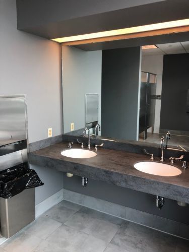 A bathroom with two sinks and a large mirror.