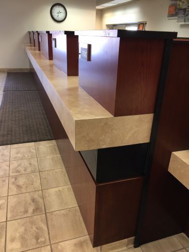 A long wooden counter with a clock on the wall above it