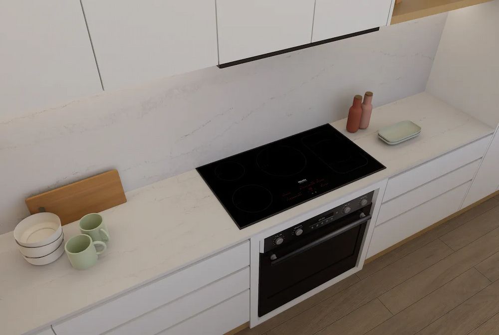 A kitchen with a black stove top oven and white cabinets — Better Stone in Caloundra West, QLD