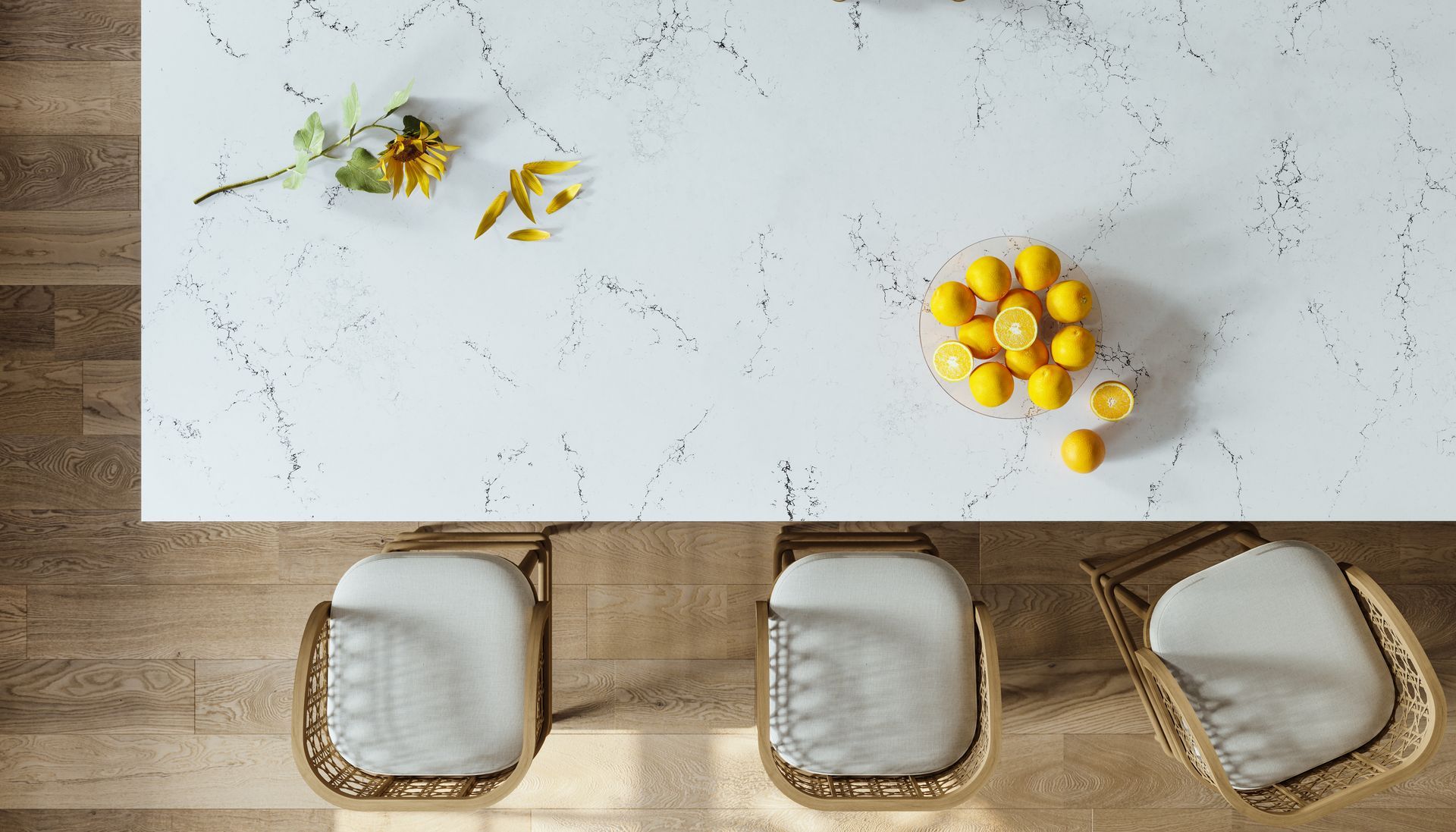 A white marble counter top with a bowl of lemons on it.