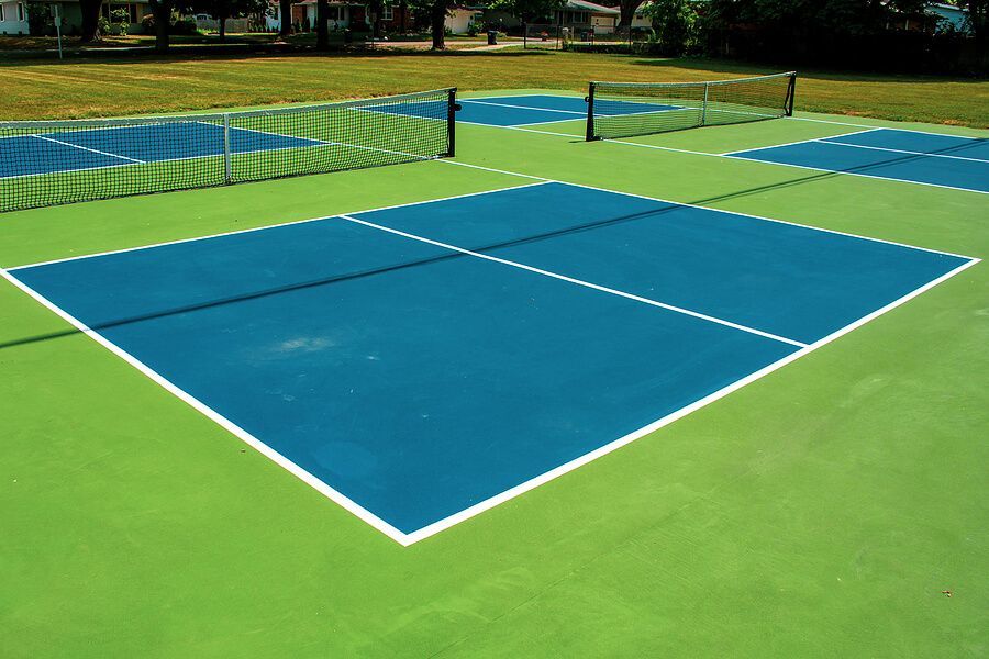 A blue and green tennis court with a net