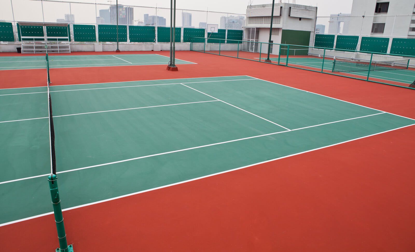 A green and red tennis court with white lines