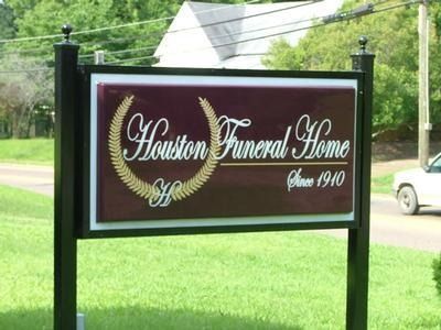Sign for Houston Funeral Home, burgundy background with gold lettering, laurel wreath, and 
