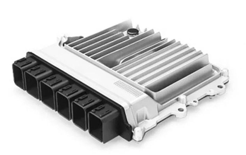 Silver automotive electronic control unit with black connector ports and cooling fins on a white background