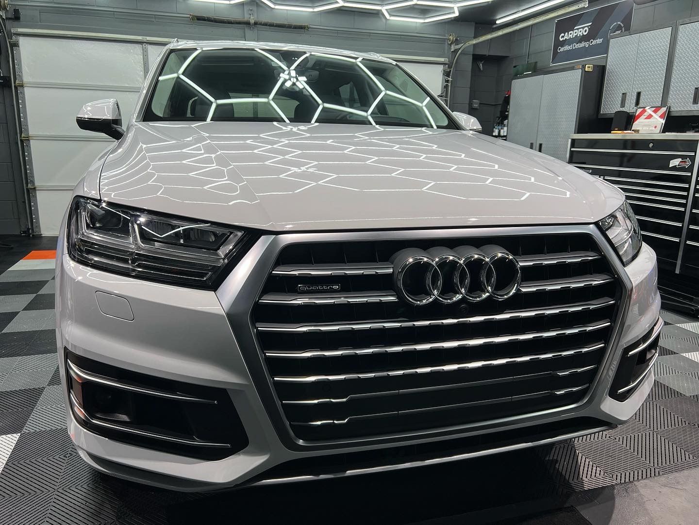A white audi q7 is parked in a garage.