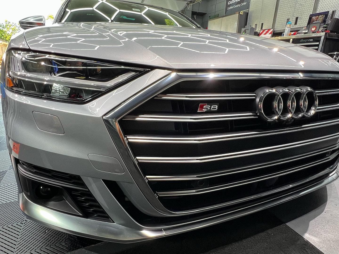 A silver audi a8 is parked in a garage.