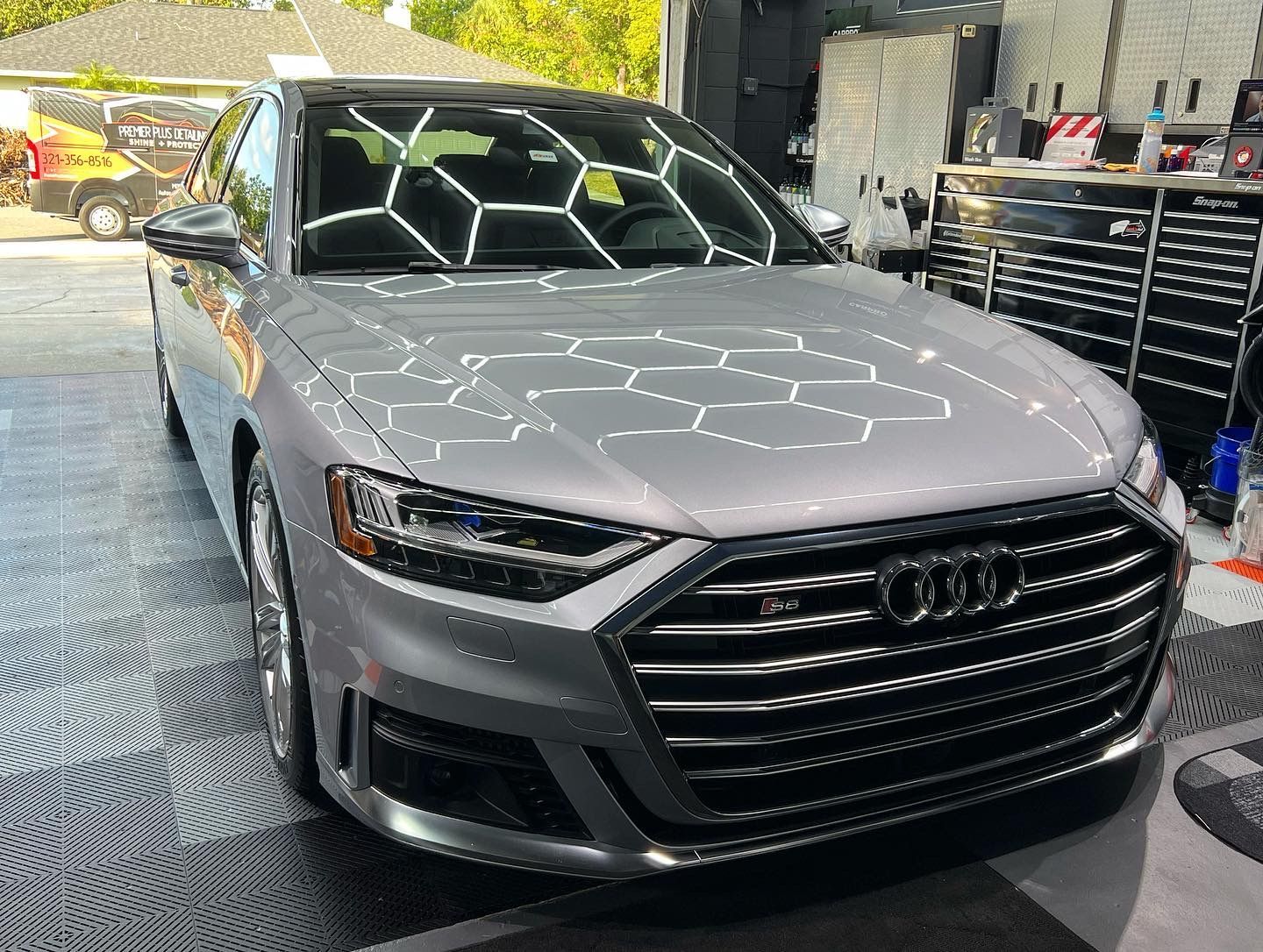 A gray audi a8 is parked in a garage.