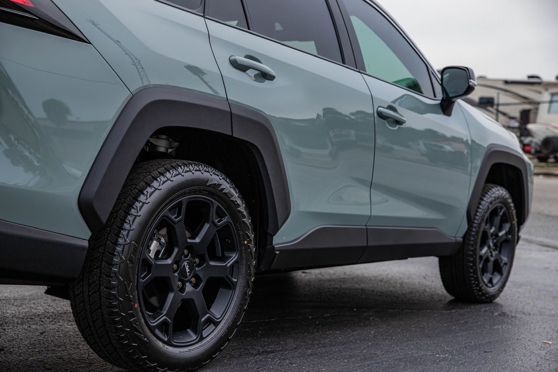 A toyota rav4 is parked on the side of the road in the rain.