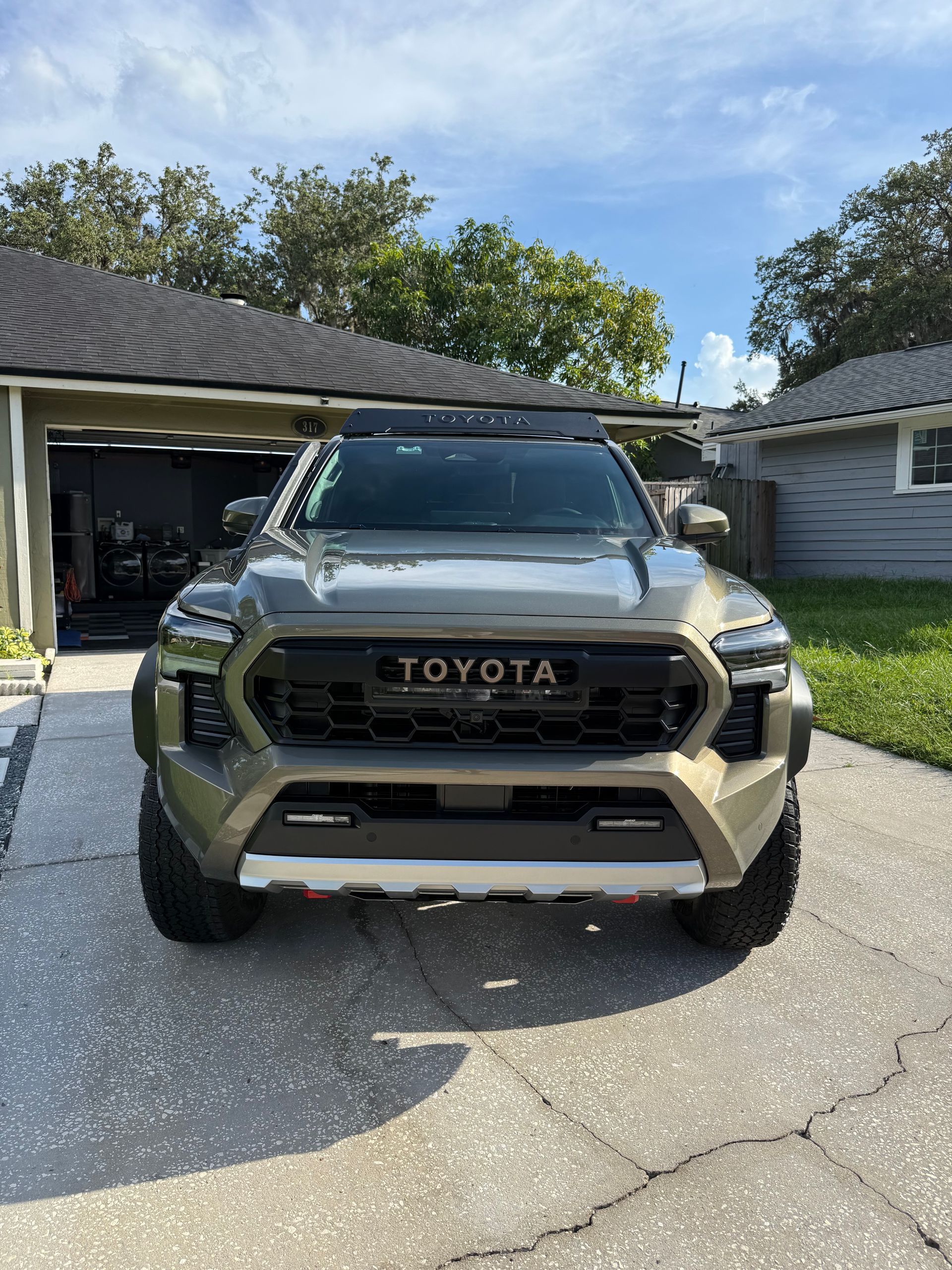 A toyota truck is parked in a driveway in front of a house.