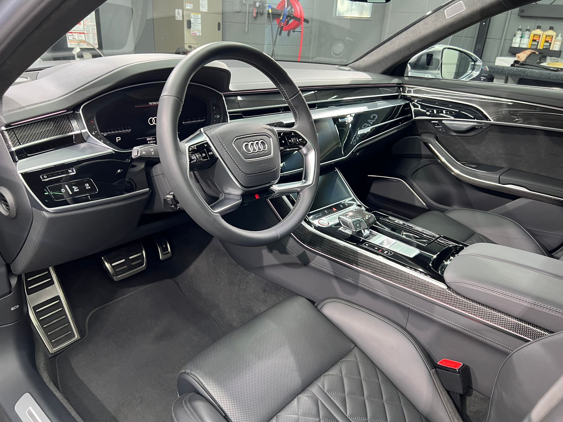 The interior of a car with a steering wheel and dashboard
