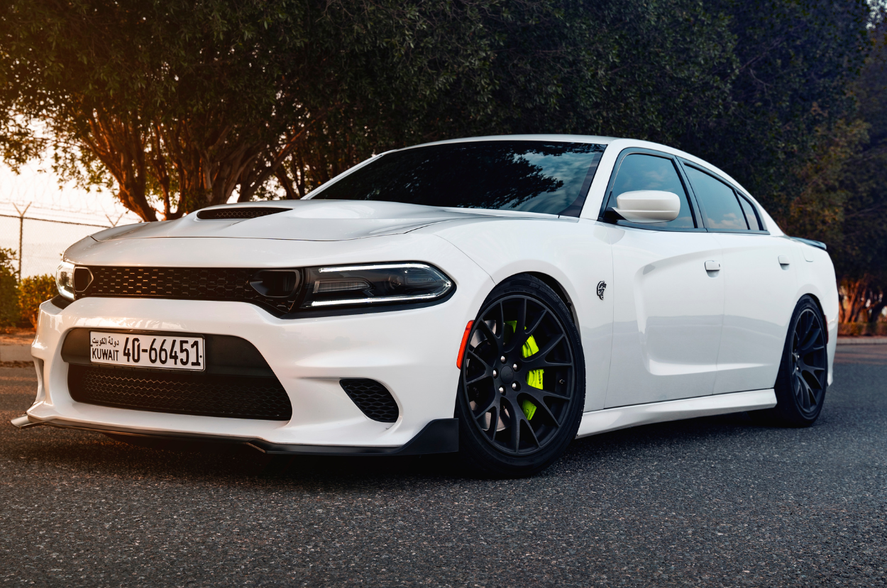 A white dodge charger is parked on the side of the road.