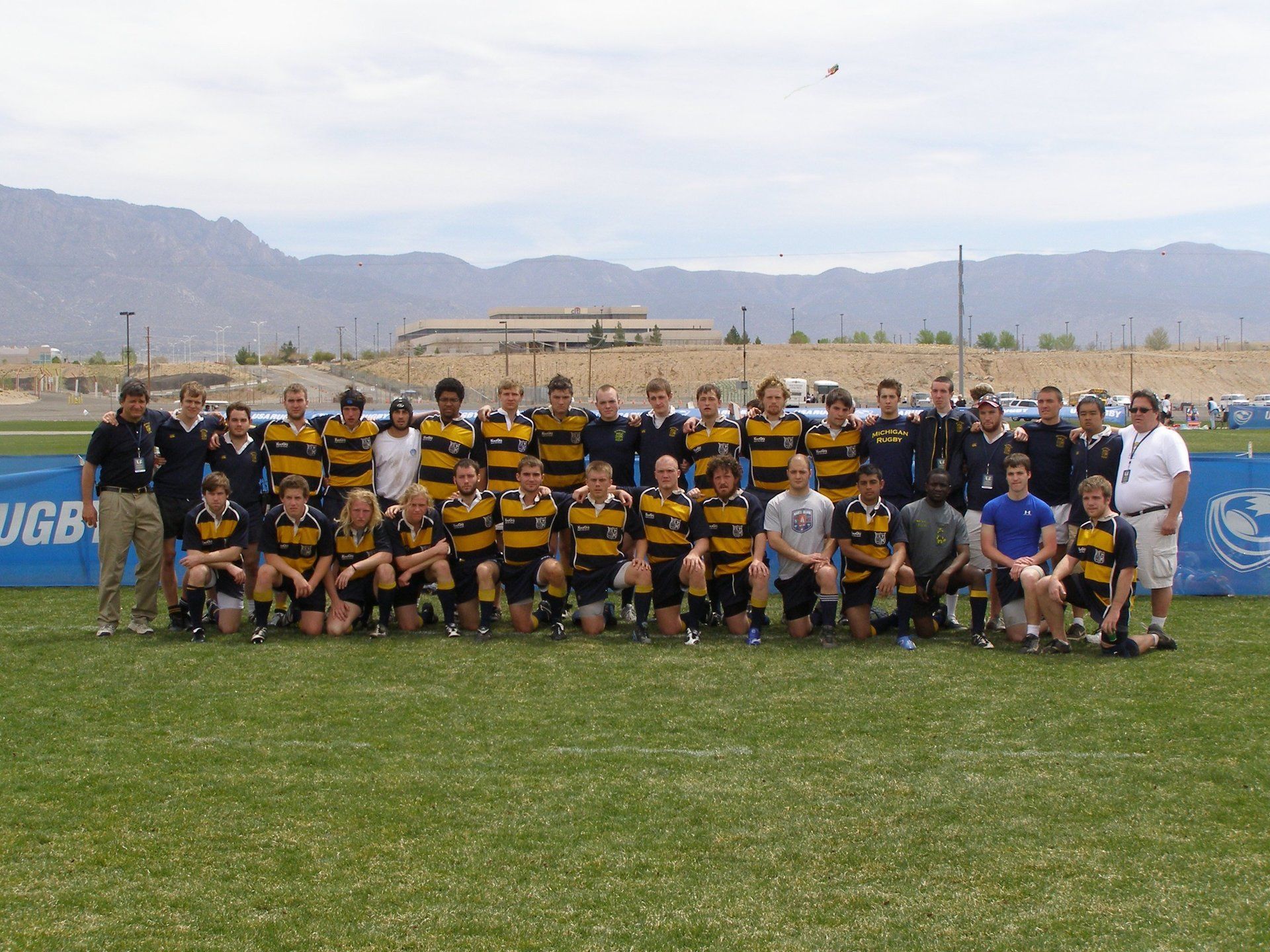 A group of people posing for a picture in front of a banner that says ugb