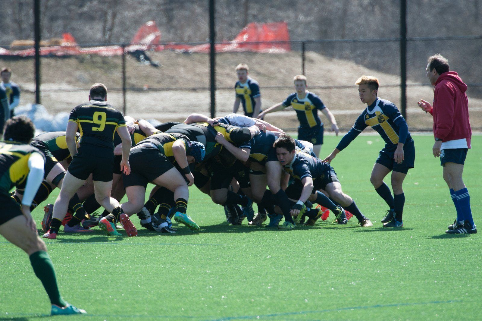 A group of rugby players are playing a game on a field.