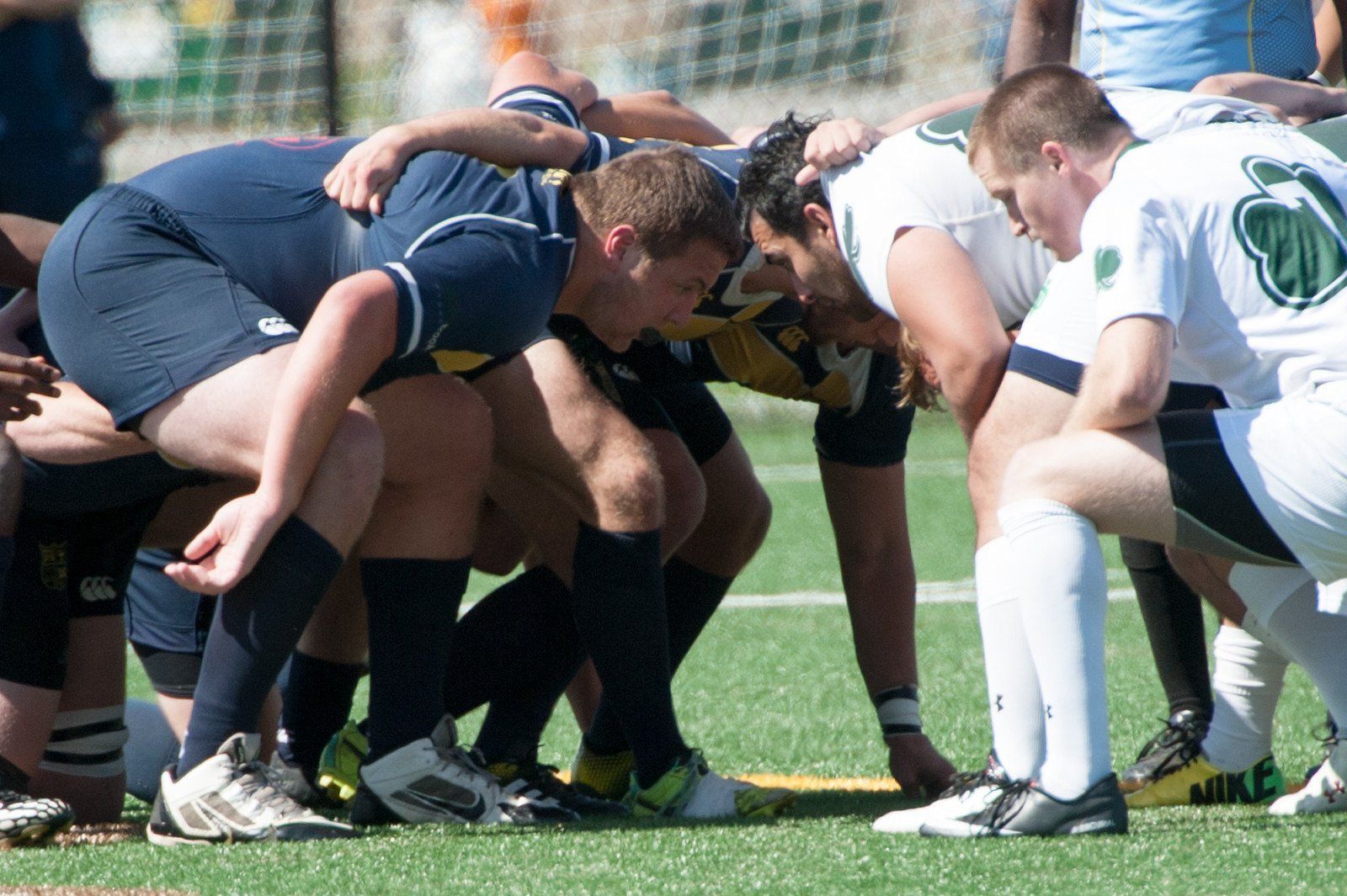 A group of rugby players huddle together on the field