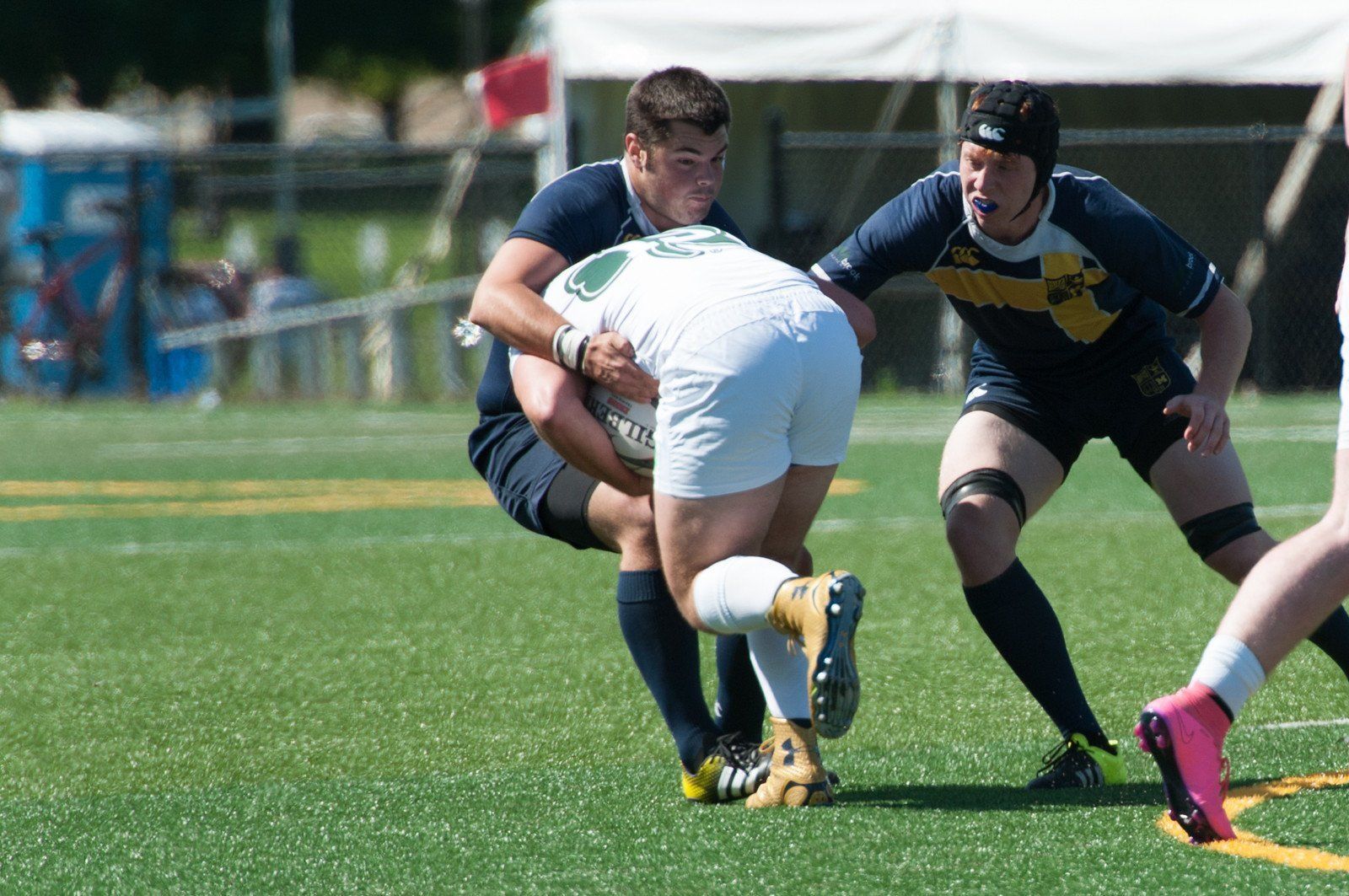 A group of men are playing rugby on a field.