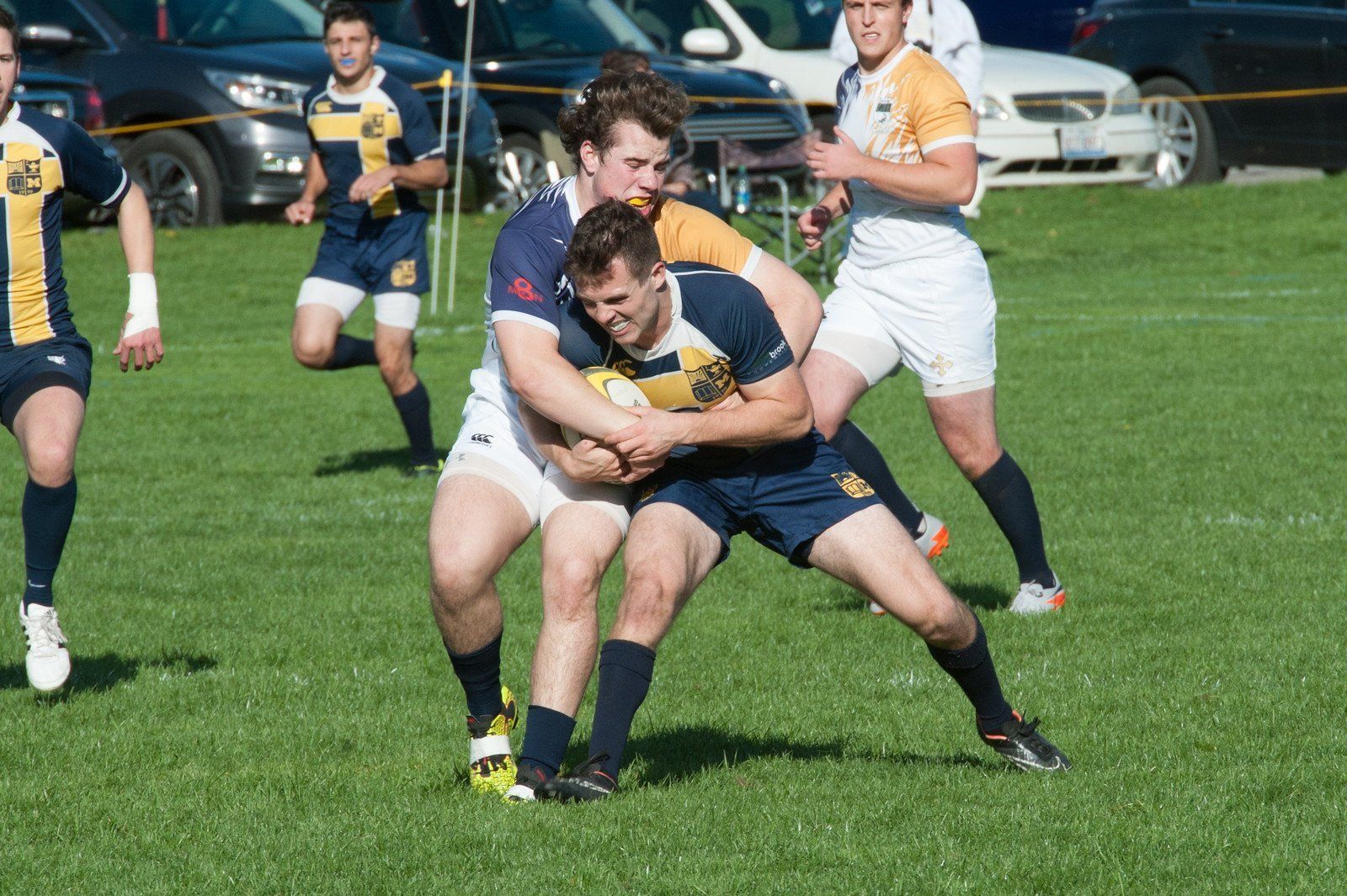 A group of men are playing rugby on a field.