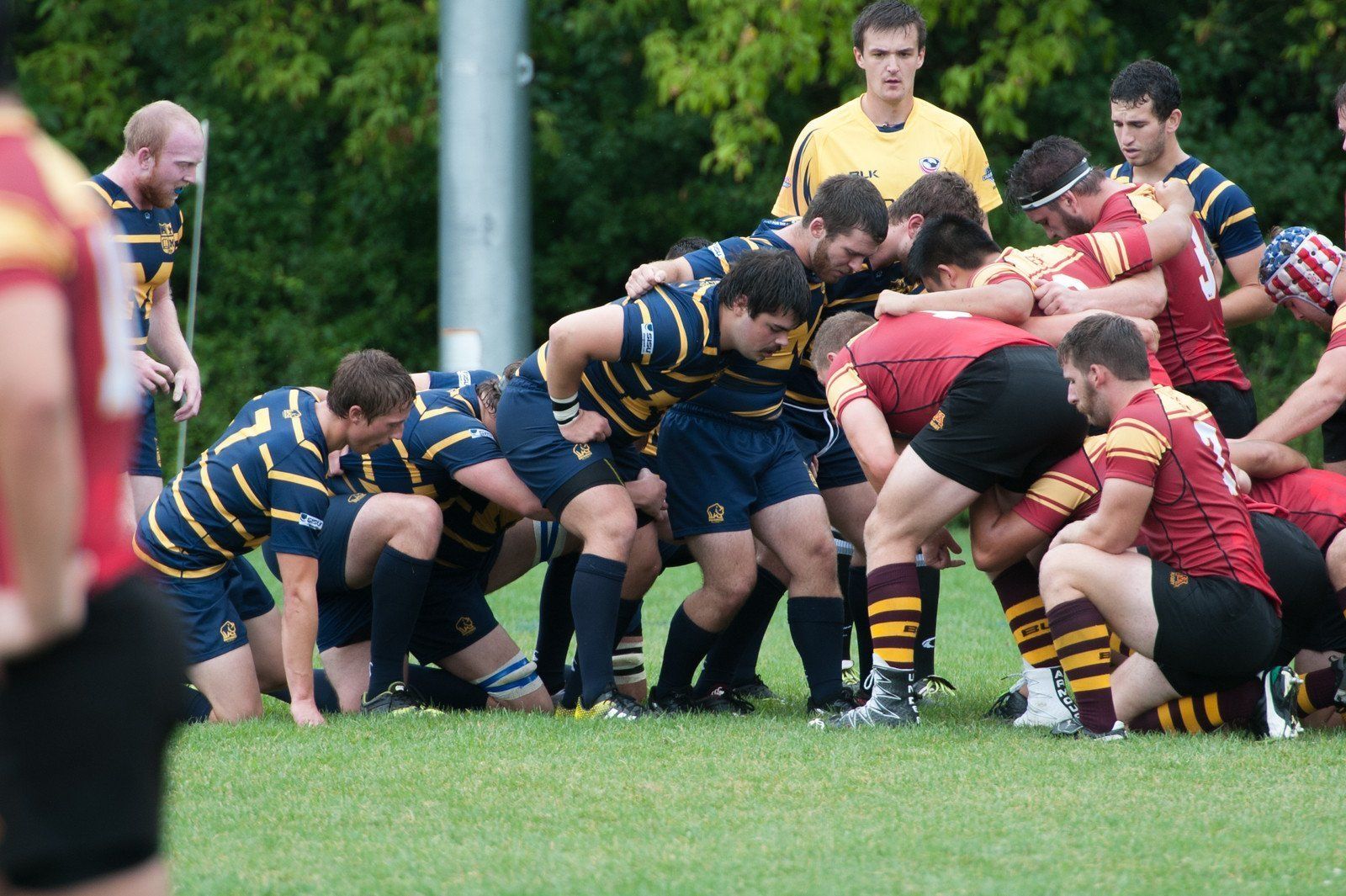 A group of rugby players are huddled together on the field