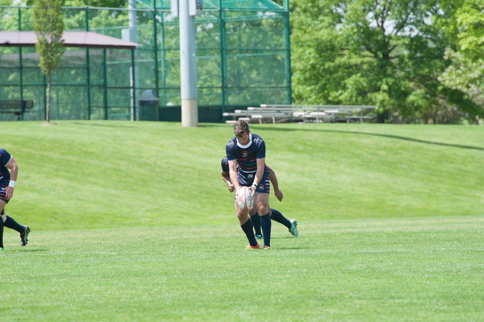 A group of people are playing rugby on a field.