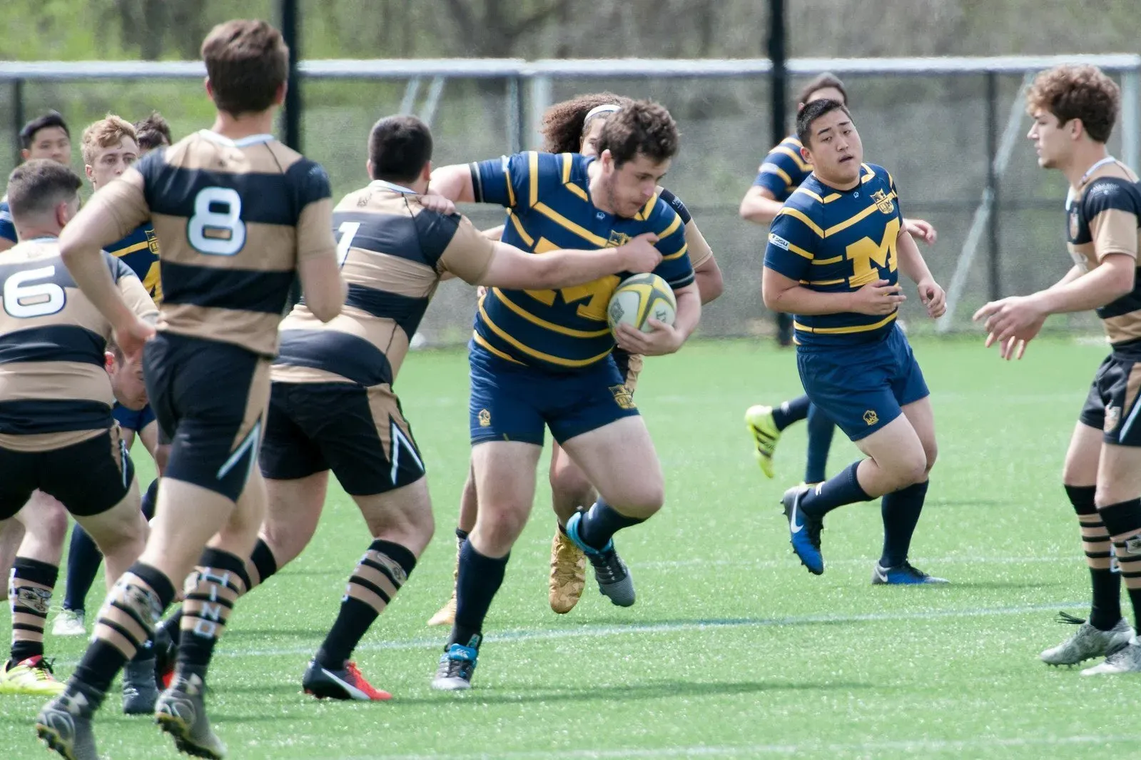 A group of young men are playing rugby on a field.