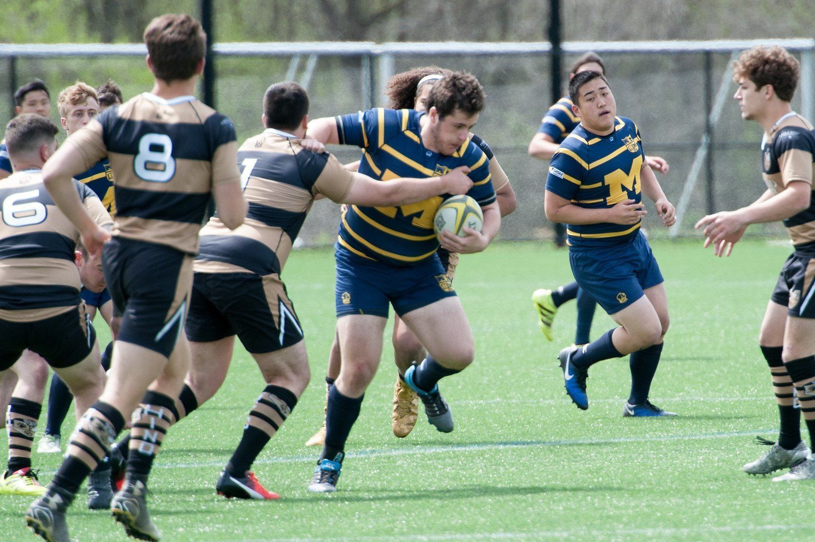 A group of young men are playing rugby on a field.
