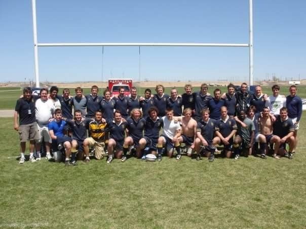 A group of men are posing for a picture on a field