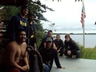 A group of men posing for a picture with one wearing a navy shirt