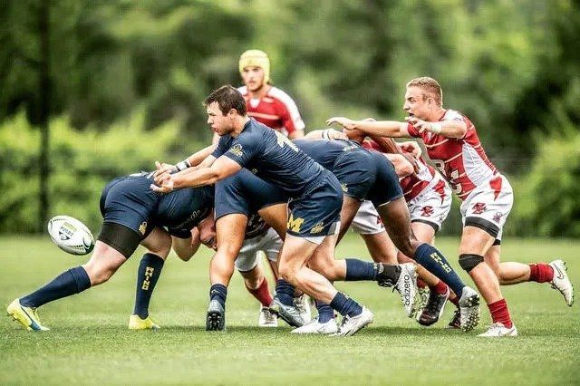 A group of men are playing rugby on a field.