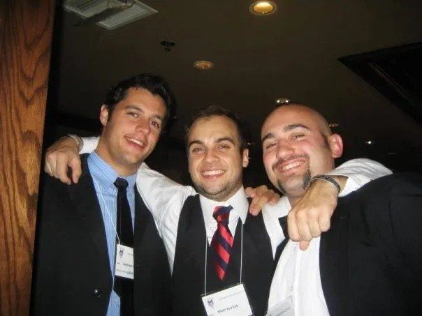 Three men in suits and ties are posing for a picture