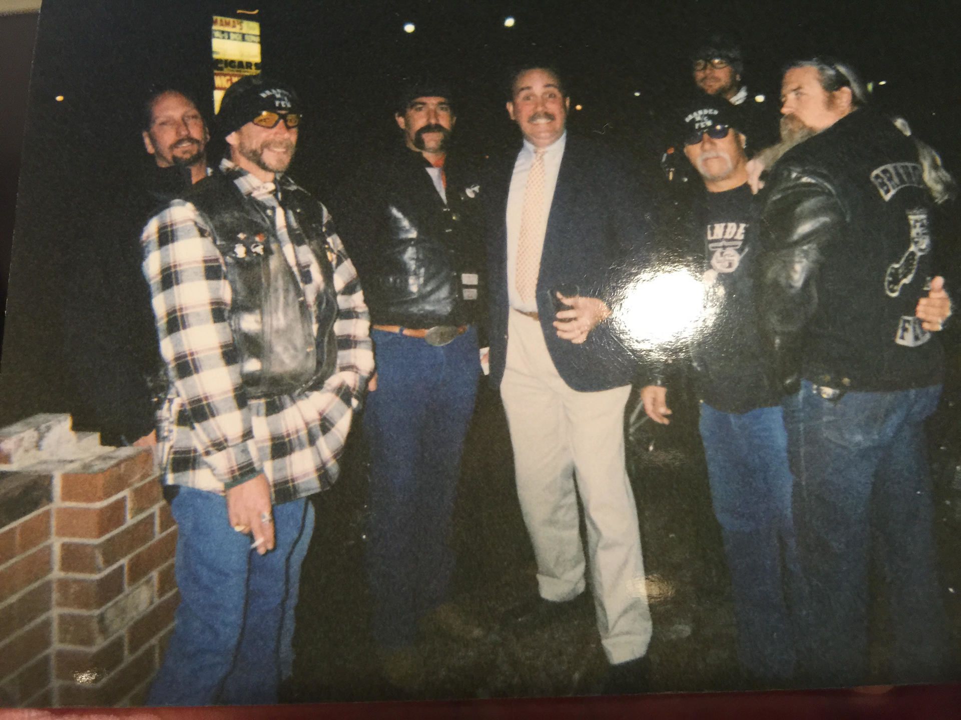 A group of men are posing for a photo with one man wearing a jacket that says bp